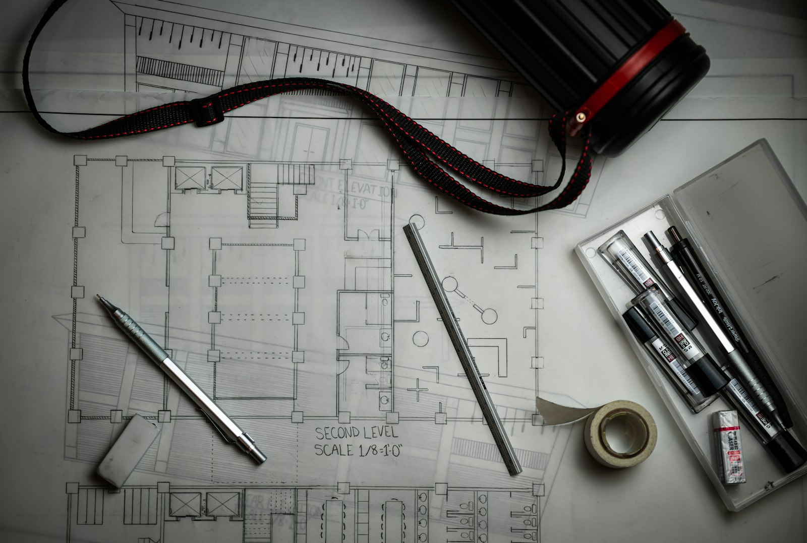 Design plans and drafting tools on a desk at RR Associates